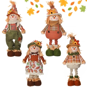 Group display of four autumn scarecrow dolls with maple leaves on white background