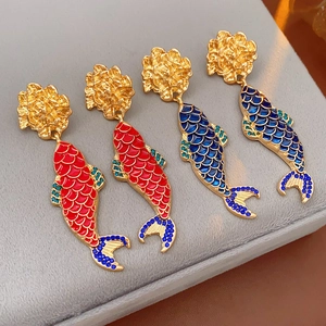 Detailed close-up of vintage koi fish earrings in red and blue enamel with rhinestones