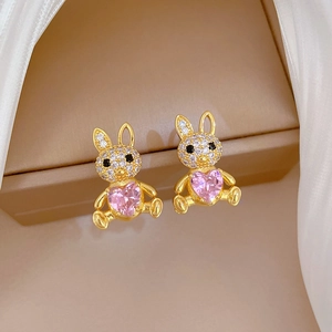 Detail of gold rabbit earrings with pink heart gemstone and sparkling diamond pave inlay