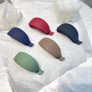 Matte banana hair clips in red, navy, black, beige and green colors shown in flat lay view