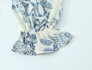Detail of elastic ruffled cuffs on square neck dress with blue floral print on white fabric