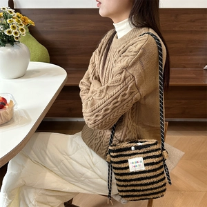 Plush rainbow polka dot bucket bag with striped pattern shown on model in cafe