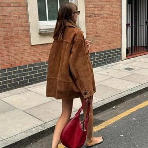 Détail de la texture suédine marron et du col vintage de la veste style urbain