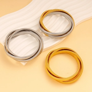 Close-up of triple-layered elastic metal bracelets in gold, silver and mixed tones