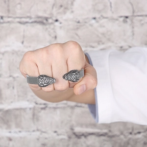 Macro detail of snake head steel ring with scales texture on male hand clenched fist