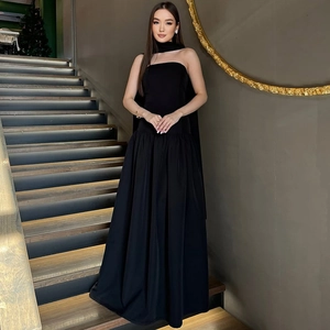 Detail of elegant black strapless maxi dress with matching neck scarf on a model