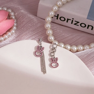 Vue détaillée de boucles d'oreilles lapin asymétriques en argent avec strass roses et franges