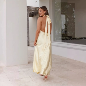 Detail of the elegant open back and tie-neck design on this yellow satin maxi dress