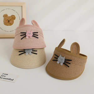 Détail de chapeaux en paille pour enfants avec de mignons motifs de chat et oreilles de lapin