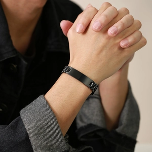Close-up of black stainless steel watchband style bracelet with engravable id plate on wrist