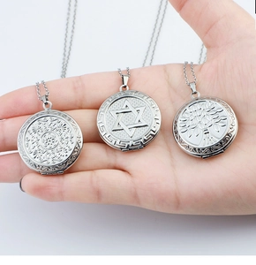 Macro detail of three silver heart locket pendants with flower, star, and tree engravings