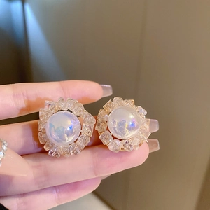 Macro shot of oversized flower earrings with imitation pearls and sparkling crystals