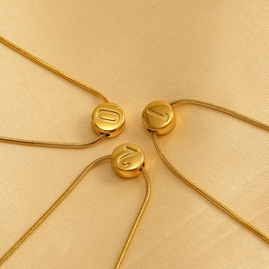 18K vergoldete Edelstahl-Zahlenanhängerkette auf luxuriösem goldenem Satin-Hintergrund