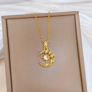 Close-up of gold moon and star pendant with opal stone on beige silk background