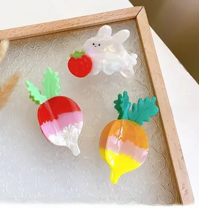 Detail showing a cute rabbit and carrot acetate hair clips set on an elegant glass tray