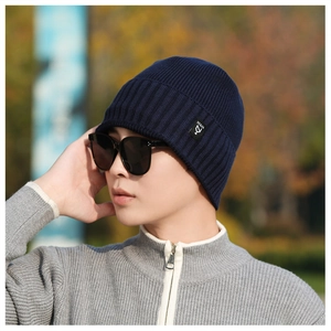 Detail of dark blue ribbed knit beanie with NY&JA brand label worn in outdoor setting