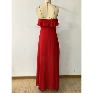 Detail of red chiffon maxi dress showing thin straps and cross-back ruffle design