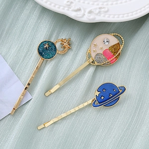 Detailed view of three starry sky hair clips with enamel stars and glitter accents