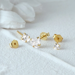 Macro shot of S925 sterling silver heart earring with white cubic zirconia in gold plating