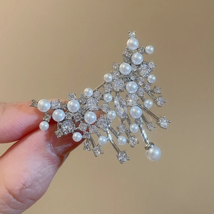 Macro shot of silver vintage brooch with pearls and cubic zirconia details
