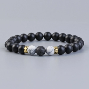 Lava rock and marble bead aromatherapy bracelet with gold accents on a grey background