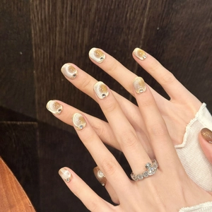 Faux ongles œil de chat courts en dégradé doré champagne avec accent en cristal brillant