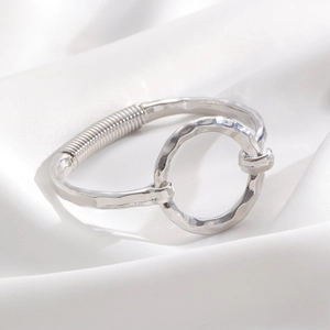 Detail of silver alloy cuff bracelet with hammered texture and spring coil elements