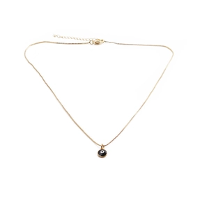 Collana a catena dorata con ciondolo occhio del diavolo bianco e nero su sfondo bianco