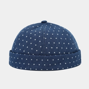 Detail of dark blue denim brimless docker hat with white square polka dot pattern