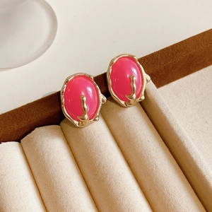 Vue détaillée des boucles d'oreilles vintage en résine rose avec montures dorées texturées