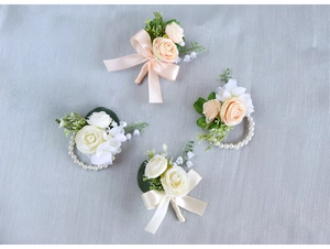 Detail of light pink rose boutonniere and pearl wrist corsage set for weddings