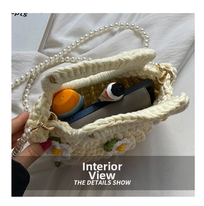 Interior view of crochet shell bag showing storage for phone and pearl strap detail