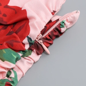Détail du tissu à fleurs roses avec roses rouges et fermeture éclair invisible assortie