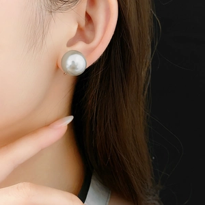 Close-up of a large 14mm light grey pearl ear cuff worn on a model ear for a minimalist look