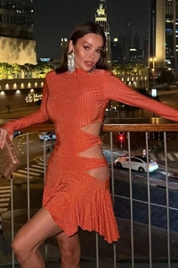 Détail de la robe orange à strass avec découpes latérales et design plissé en vue de nuit