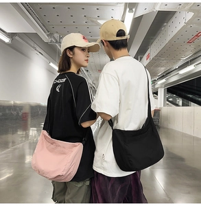 Wide adjustable fabric strap and spacious crescent shape of this nylon messenger bag