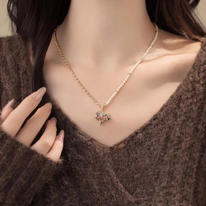 Gold plated necklace with half pearl chain and colorful gemstone map pendant on a model
