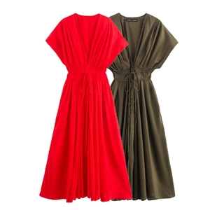 Détail de robes midi rouge et vert olive avec col en V, ceinture et jupe plissée