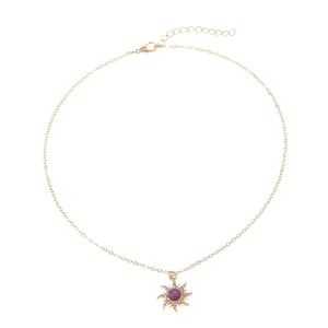 Vintage gold sunburst necklace set with purple gemstone and sparkling white rhinestones