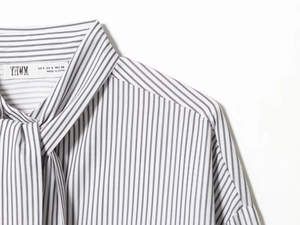 Détail du col écharpe rayé noir et blanc et de l'étiquette de cette blouse en popeline