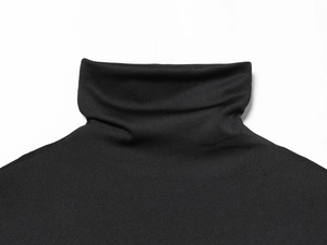 Détail du col montant noir en maille et texture fine du tissu sur le haut élégant