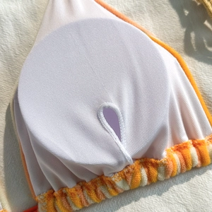 Detailed macro view of striped bikini top featuring inner lining and removable padding