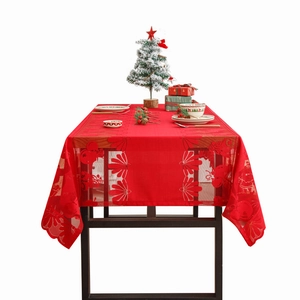 Red Christmas lace tablecloth with hollow patterns of trees and bells on a festive table