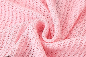 Close-up of pink knitted fabric showing breathable hollow texture and soft material