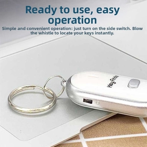 Macro detail of silver key finder on laptop with side power switch and metal keyring