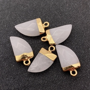 Macro view of five chili-shaped white natural stone pendants with gold metal caps