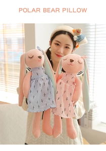 Two cute pink plush rabbits wearing blue and pink floral dresses held by a model.