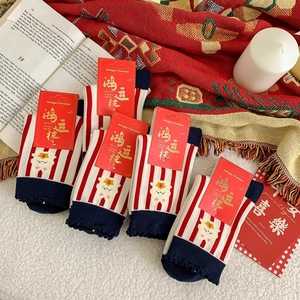Detail of red and white striped cotton socks with cute sheep embroidery and gift packaging