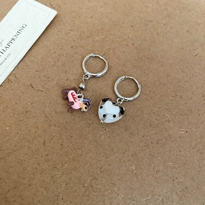 Asymmetric earrings featuring a brown cartoon dog and black white cow print heart charms