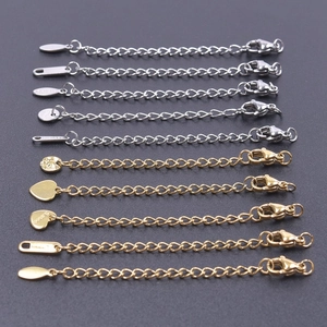 Detailed view of 5cm gold and silver necklace extenders with lobster clasps and charms